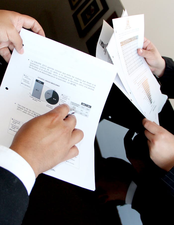 gallery-05 A business team reviewing charts and graphs on documents, emphasizing data analysis and teamwork.
